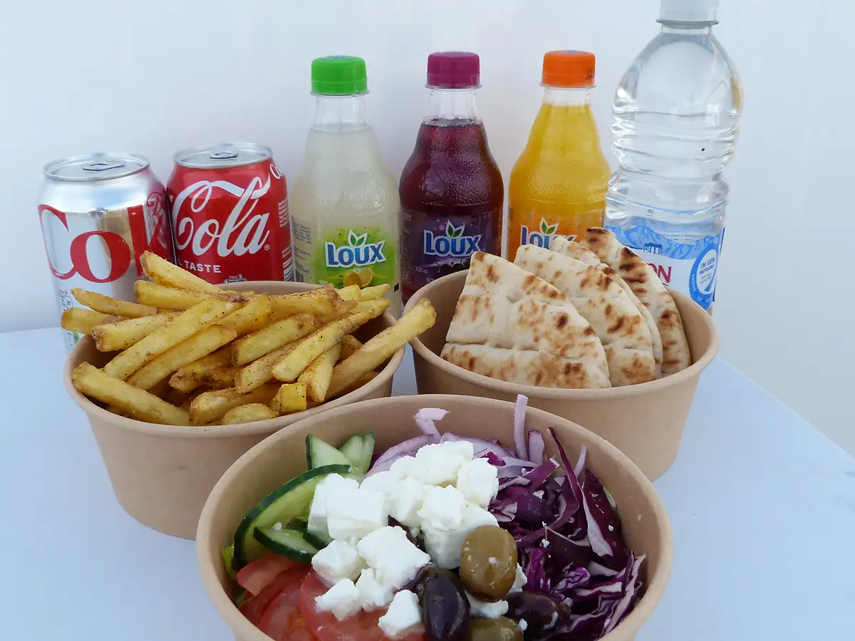 Fries, flatbread and a Greek salad box with feta and olives, with Loux and soft drinks behind